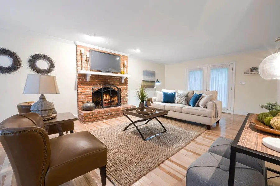 Lit brick fireplace in a New Jersey suburban living room with hardwood floors
